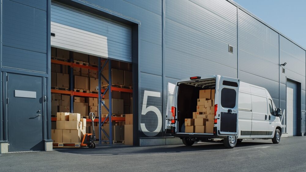 A delivery van outside a logistics warehouse